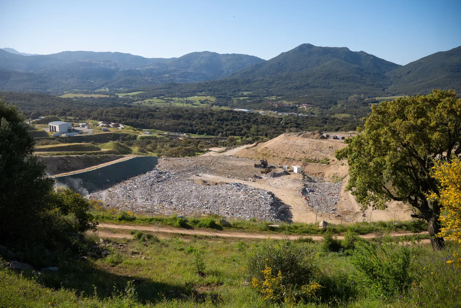 Vue paysagère de la zone d'enfouissement de l'ISDND avec le maquis en arrière-plan